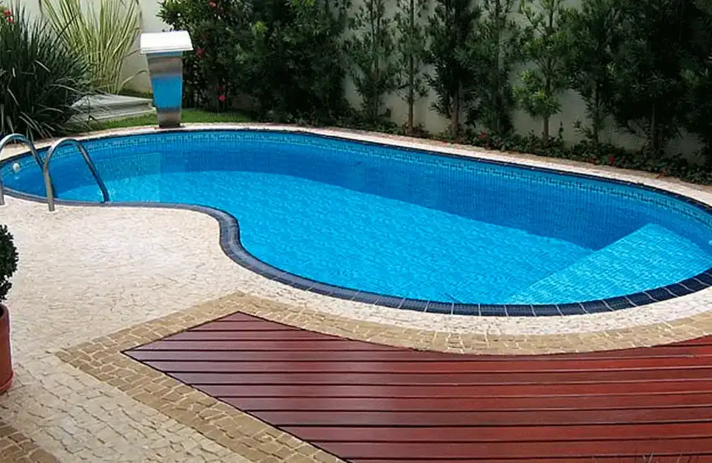 piscina com formato ondulado e deck de madeira na borda 