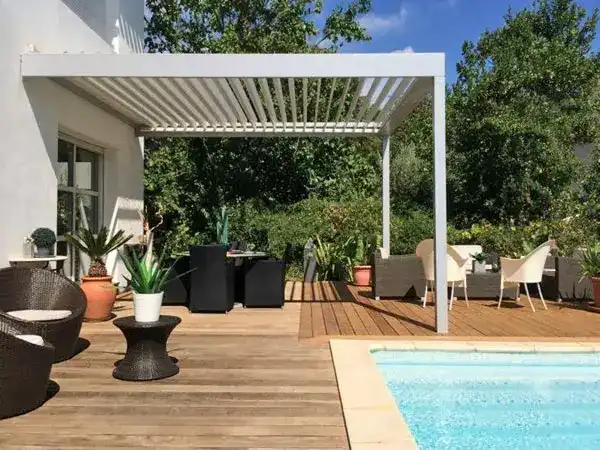 pergolado com mesas e cadeiras na área de lazer com piscina