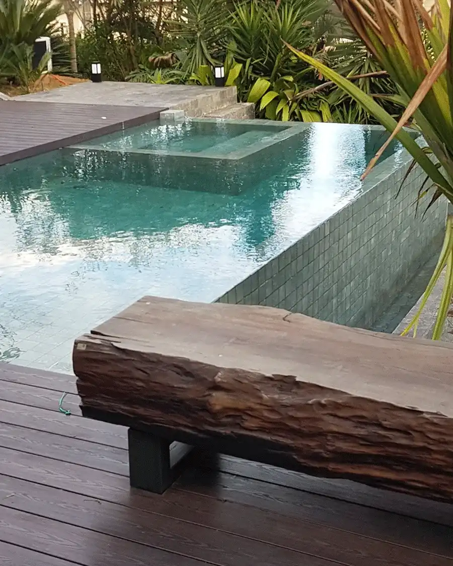 Piscina borda infinita e banco de tora de madeira 