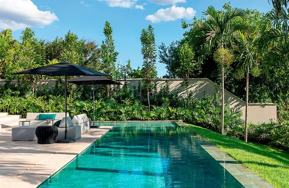 Piscina com ceramica e paisagismo no entorno 