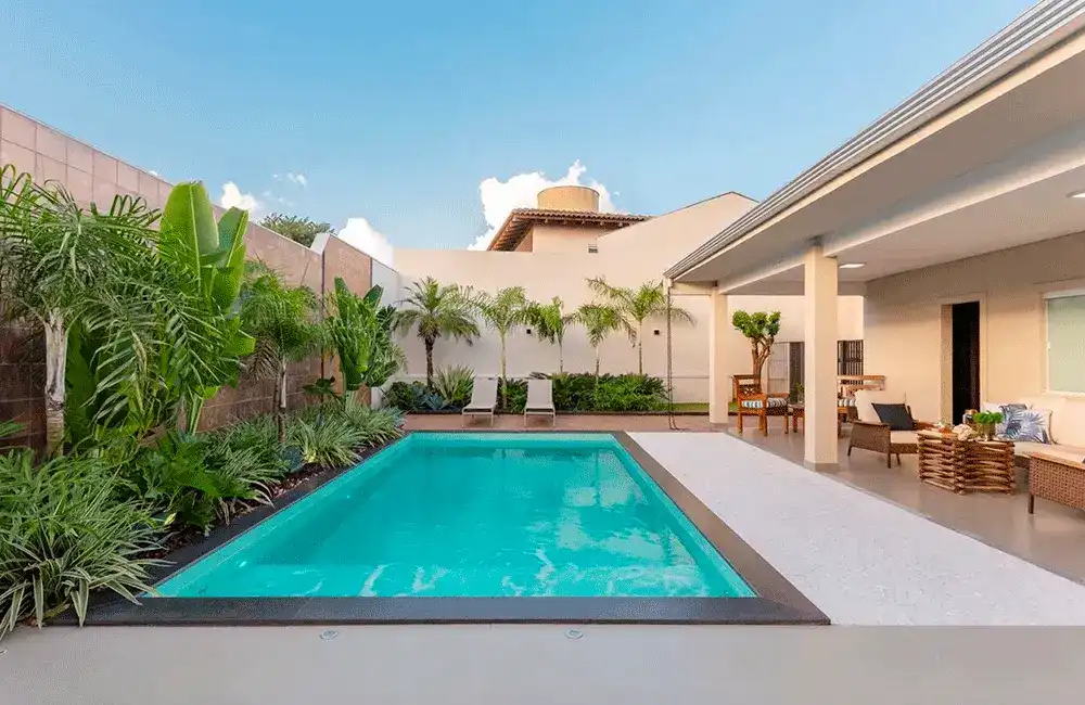 Paisagismo de piscina com borda preta e branca em contraste 