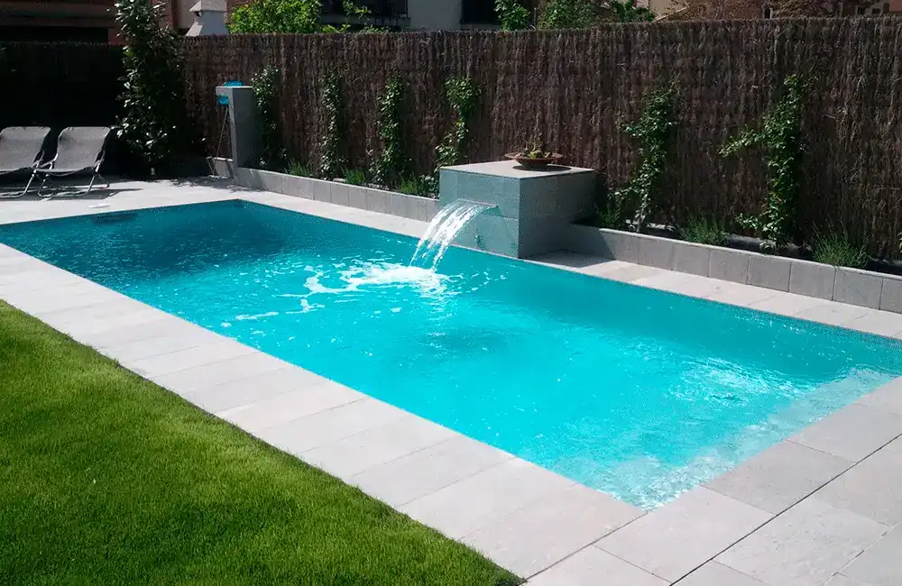 piscina com cascata e revestimento cimenticio em volta