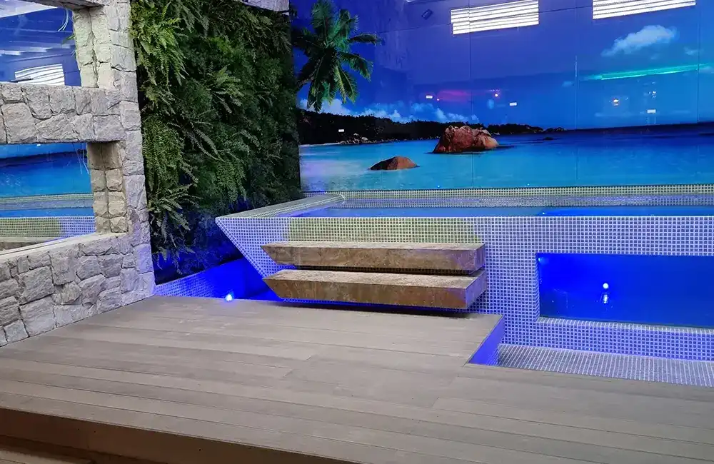 area de lazer com piscina e plotagem de praia no fundo com deck ecológico, parede de pedras, jardim vertical