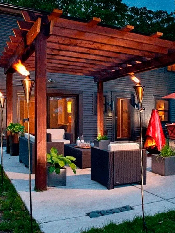 área gourmet com iluminação e pergolado feito em madeira