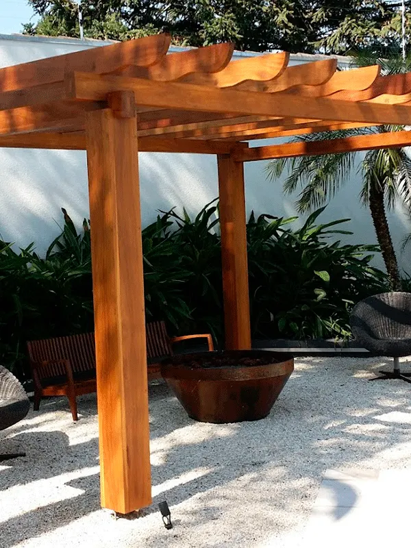 espaço pequeno com pergolado de madeira e pedrinhas de jardim