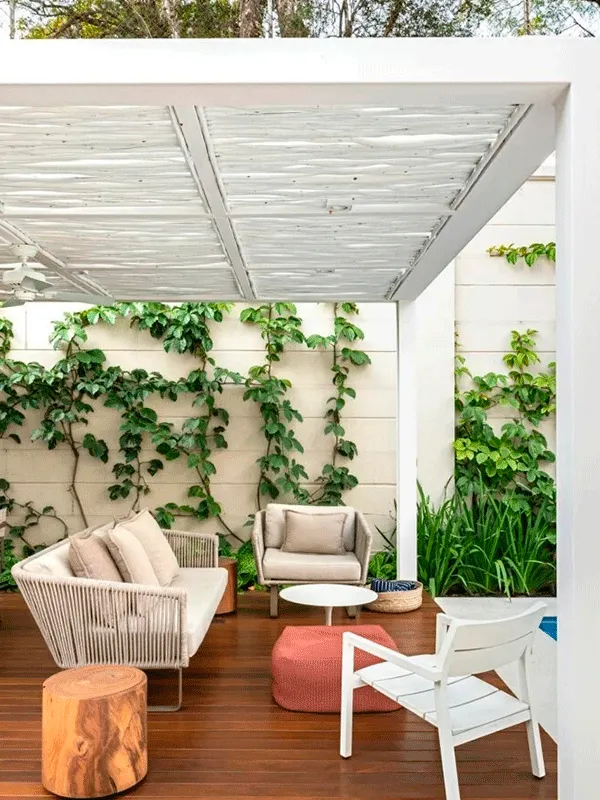 pergolado branco na área externa com deck de madeira