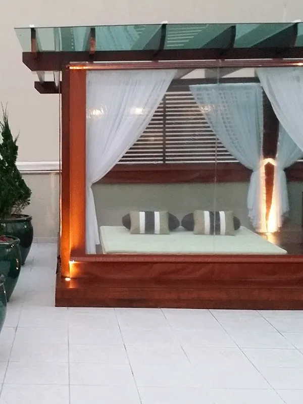 área com pergolado de vidro e cortina