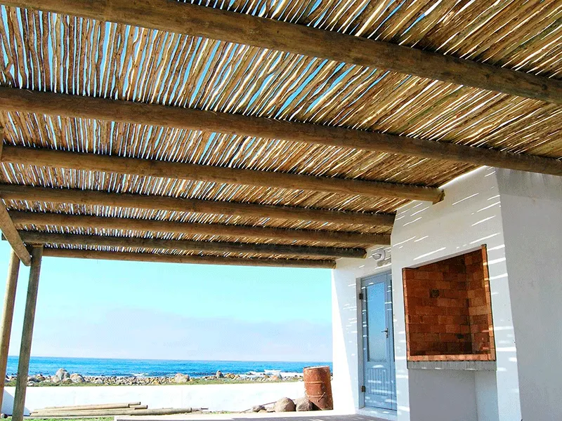 espaço de descanso no pergolado de eucalipto com forro de palha 