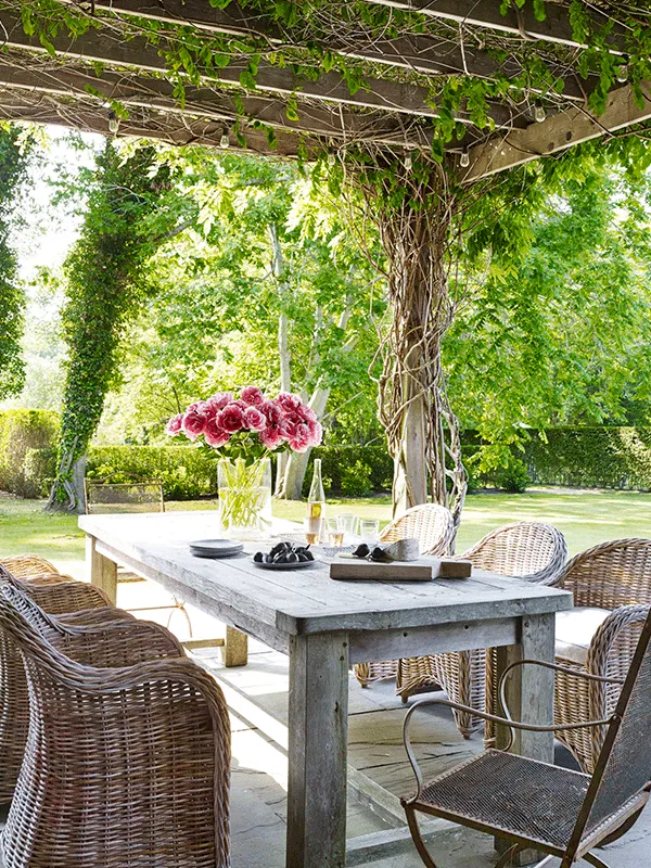 vasos de plantas na mesa dentro do pergolado de madeira de eucalipto
