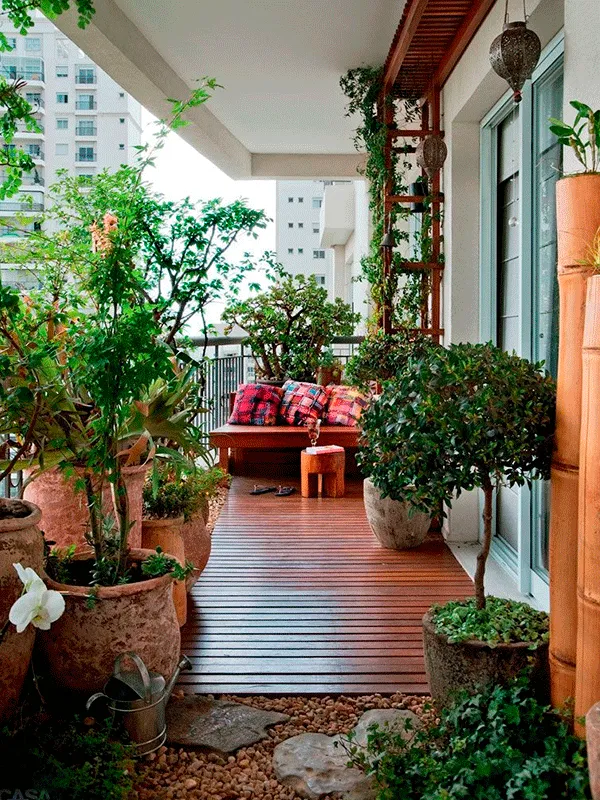 varanda com deck de madeira com muitas plantas para apartamento