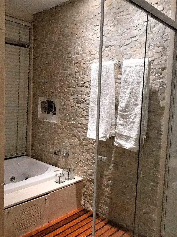 banheiro com banheira e pedra portuguesa