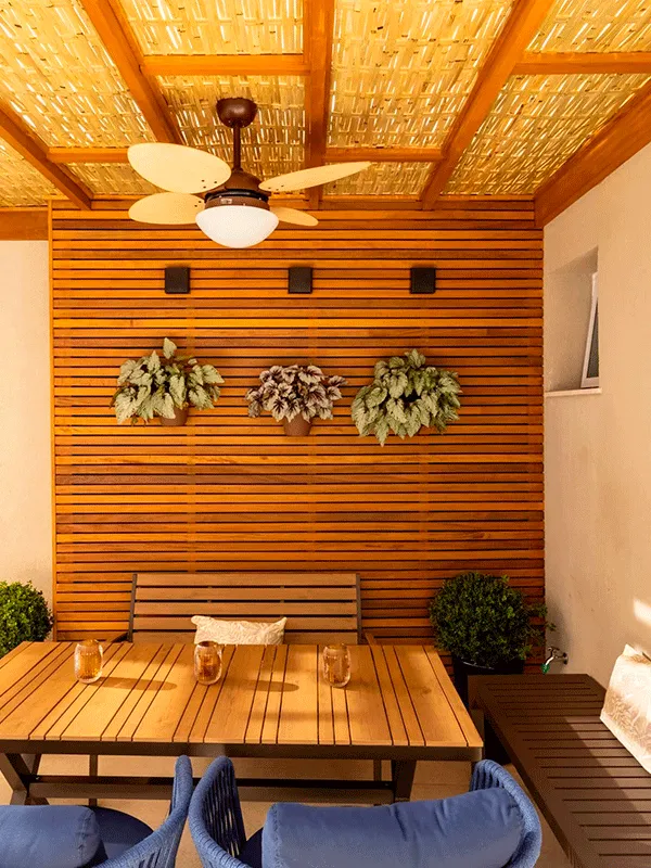 arquitetura com bastante madeira, instalado um painel ripado dentro do pergolado de madeira com cobertura de bambu