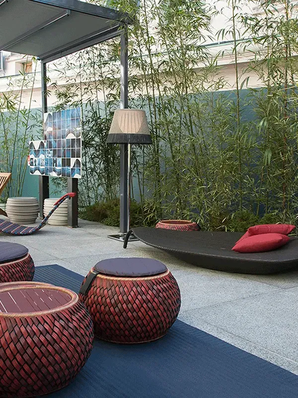 ceramica em área externa com móveis de corda e bambu na parede