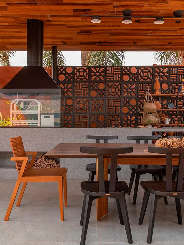 área gourmet com móveis de madeira e piso de cimento 