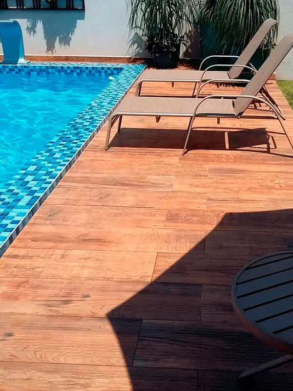 Pisos amadeirado em volta da piscina com borda elevada