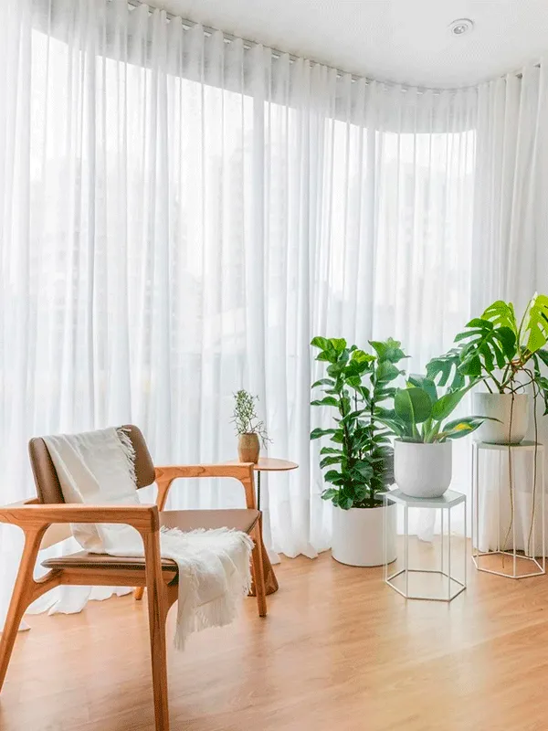 apartamento com cortinas na janela grande com piso vinilico no piso e móveis para descanso