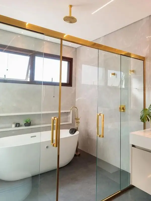 banheiro com detalhes dourado no boz com banheira
