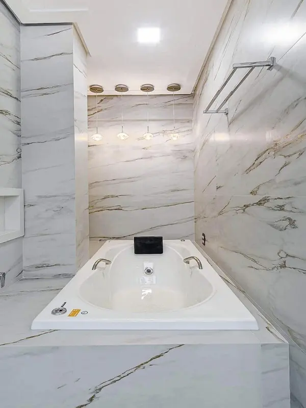banheiro grande com porcelanato marmorizado no piso e parede 