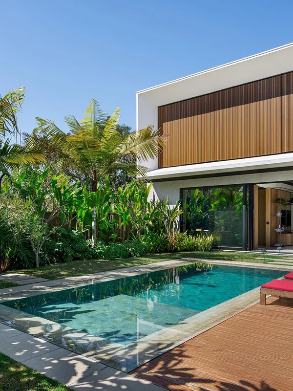 uma casa moderna com piscina e uma fachada de painel ripado que destaca