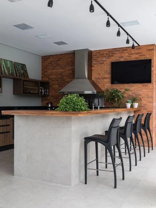 área de churrasqueira com parede de tijolinho com piso de porcelanato de cimento queimado branco