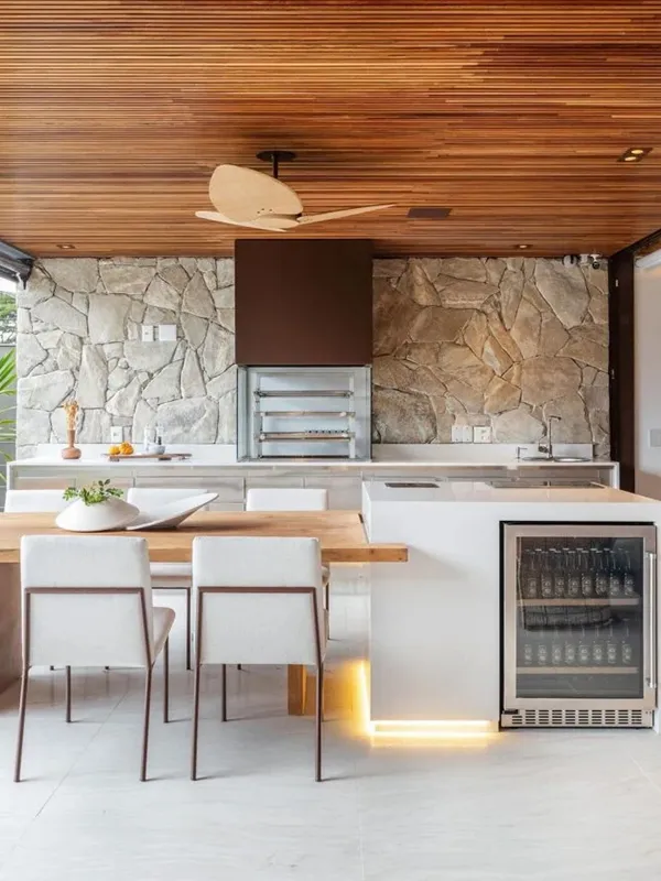Descubra os 7 Modelos de Porcelanato para Área Gourmet: Elegância e Praticidade de Limpeza 101 área de lazer pequena com pedras naturias na parede e piso de porcelanato fosco