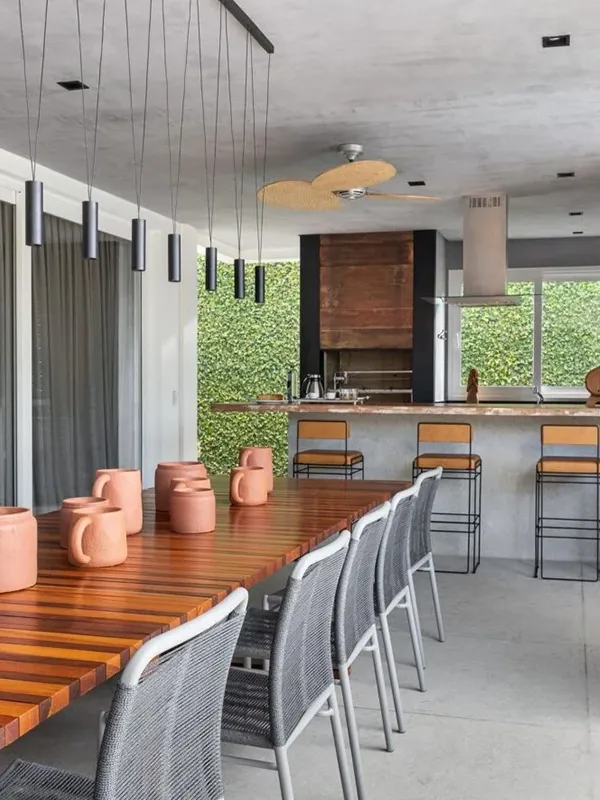 Descubra os 7 Modelos de Porcelanato para Área Gourmet: Elegância e Praticidade de Limpeza 109 ilha e mesa de madeira na área de churrasqueira
