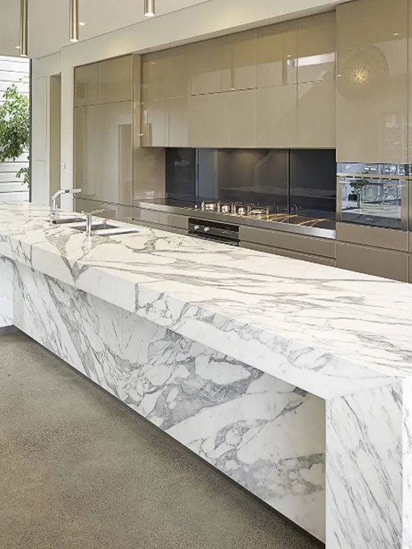 bancada grande da cozinha com marmore branco com detalhes pretos 