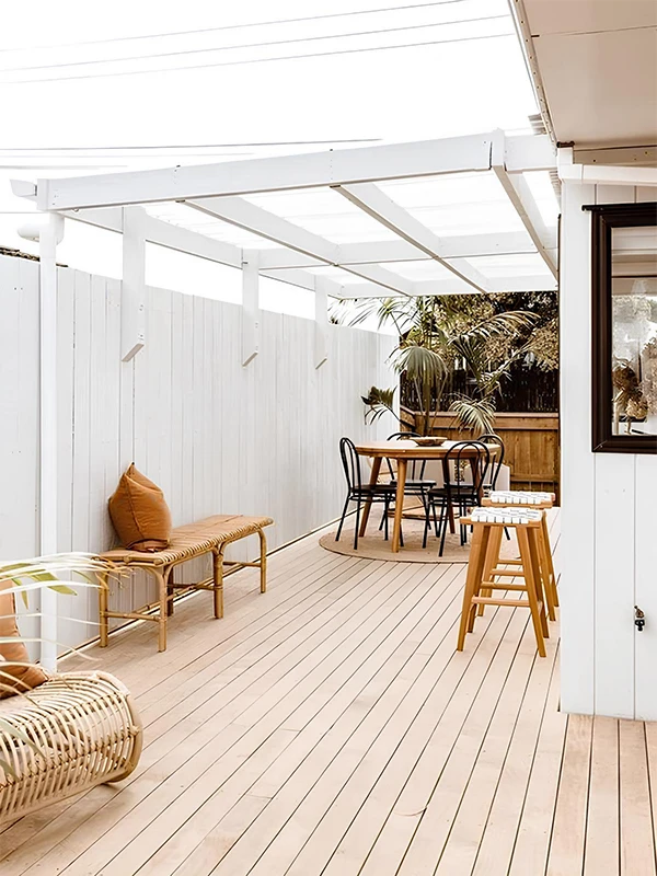 espaço pequeno com pergolado e deck ecológico aplicado no piso com móveis de madeira