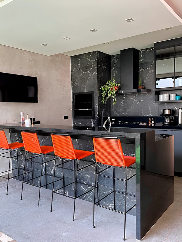 porcelanato de cimento queimado aplicado na área gourmet com bancada de porcelanato preto para destacar