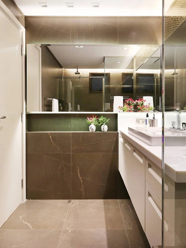 banheiro com vários tons de porcelanato, incluindo marmorizado preto com veios gold