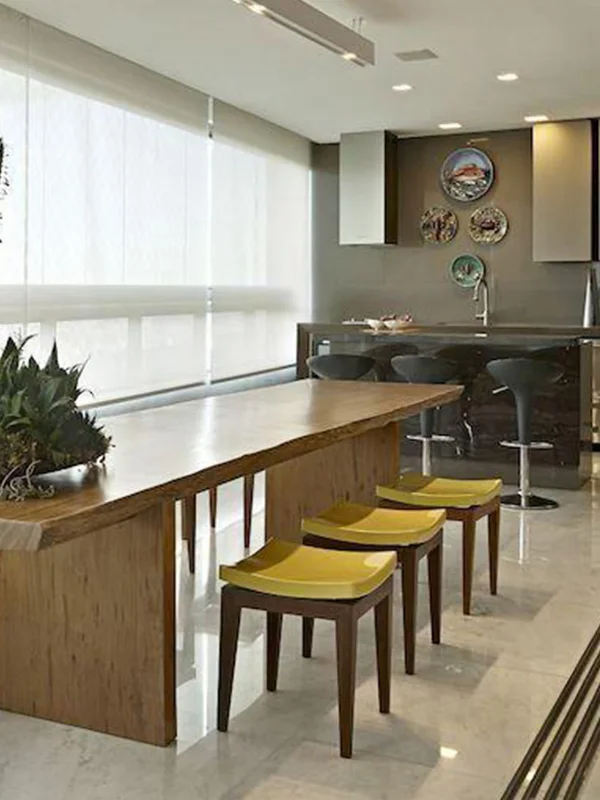 varanda espaçosa com cadeiras amarela e piso de porcelanato