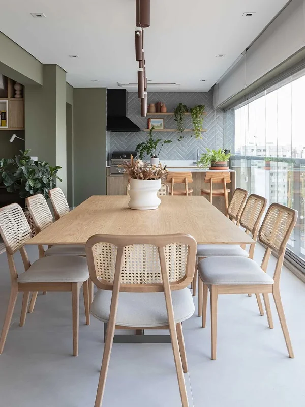 decoração clean e planejada em uma varanda grande com mesa de madeira de 8 lugares