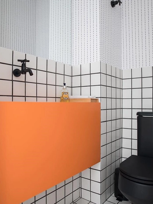 Piso de banheiro com cerâmica antiderrapante cinza e laranja.
