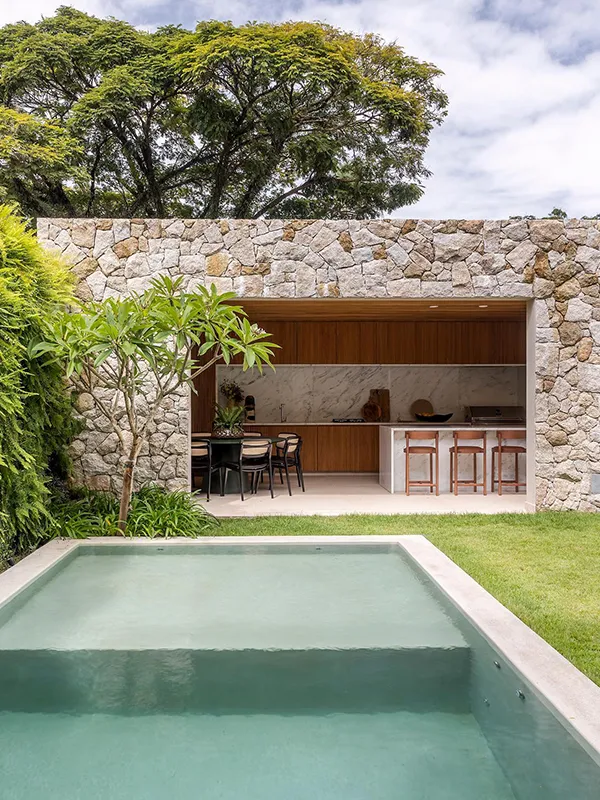 piscina verde claro com paisagiusmo de pedras naturais na decoração do quintal