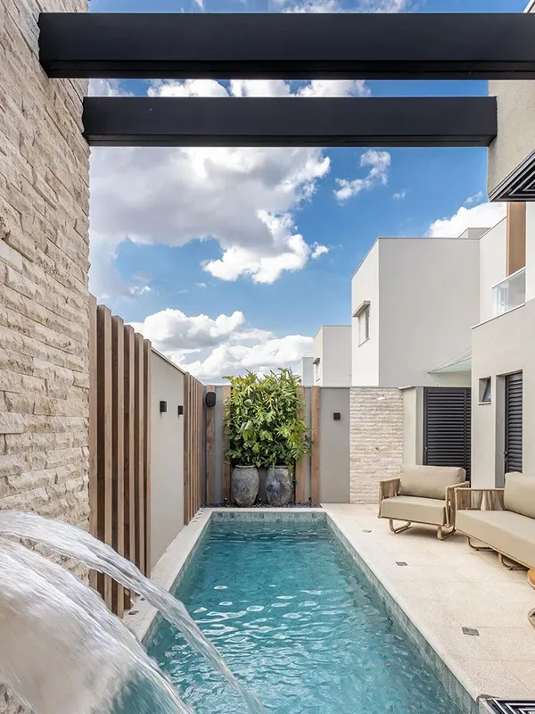 piscina com painel ripado de porcelanato na parede bem decorada