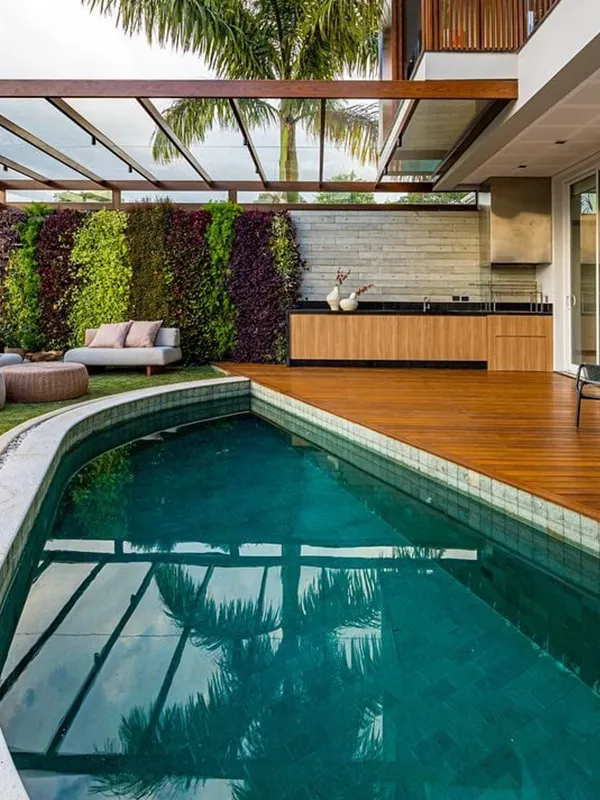 piscina com deck de madeira em volta e ceramica como revestimento principal na composição harmonica