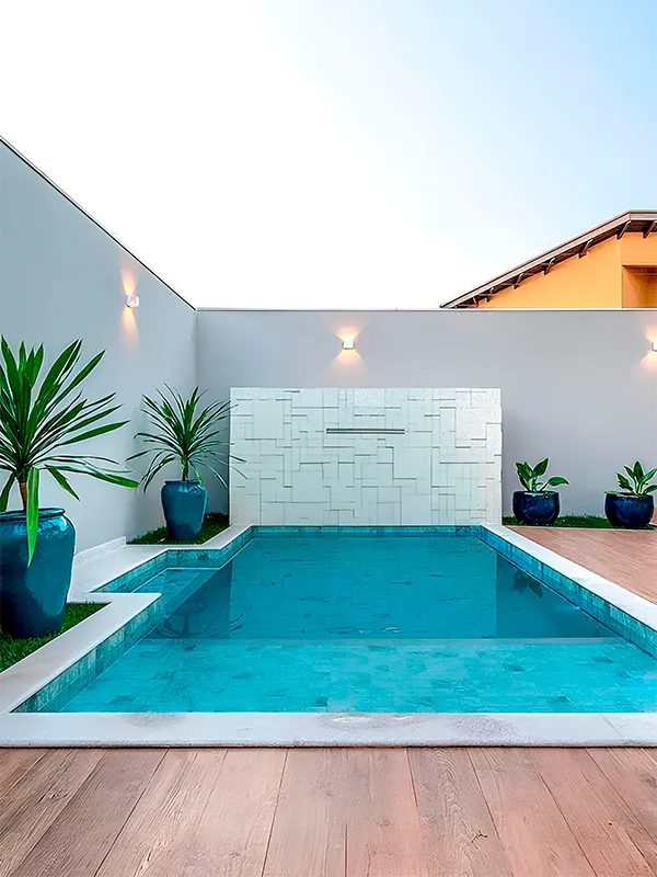 Piscina com ceramica retificado aplicado nas bordas com porcelanato amadeirado em volta 