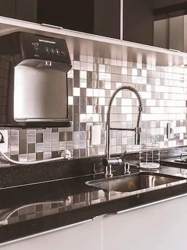 Uma cozinha com backsplash de azulejos cinza e prateados.