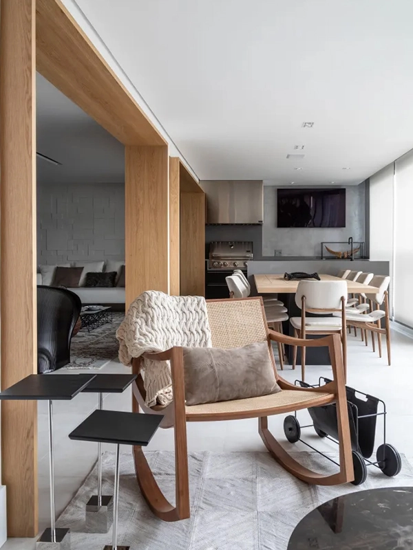 Sala de estar com cadeira de balanço e mesa de centro.