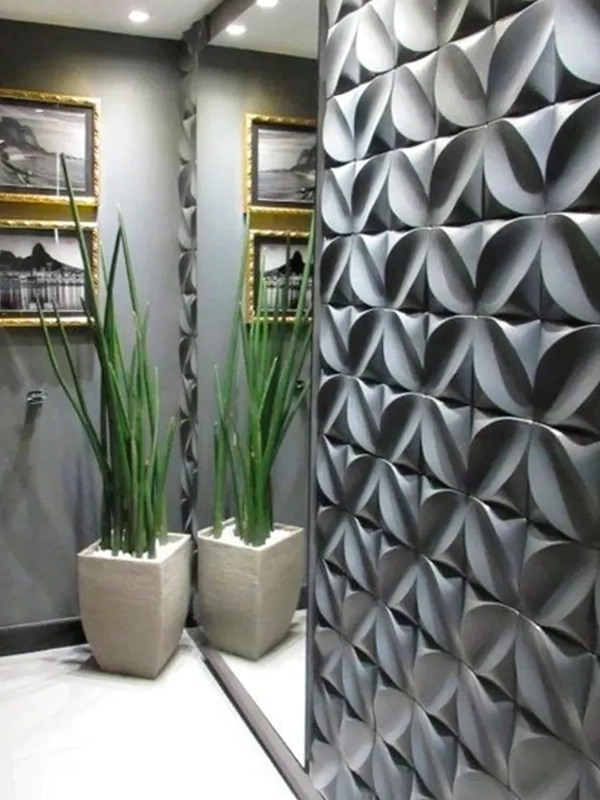 Banheiro moderno com parede geométrica e dois vasos de plantas com revestimento preto.
