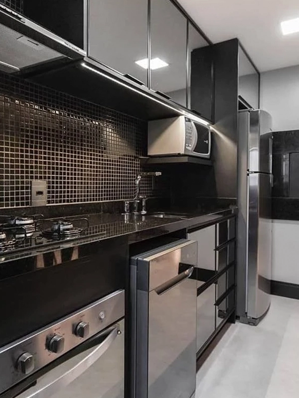 Cozinha moderna com armários Revestimento Preto, eletrodomésticos em inox e backsplash em mosaico.