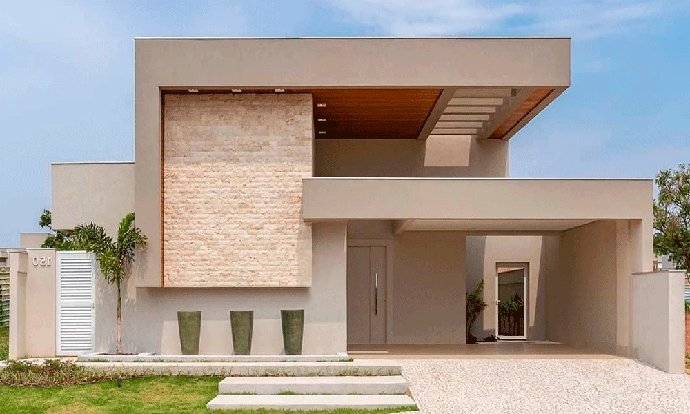 Casa moderna com telhado plano, exterior bege, grande parede de pedra, três jardineiras altas, garagem com piso de porcelanato para garagem e paisagismo minimalista.