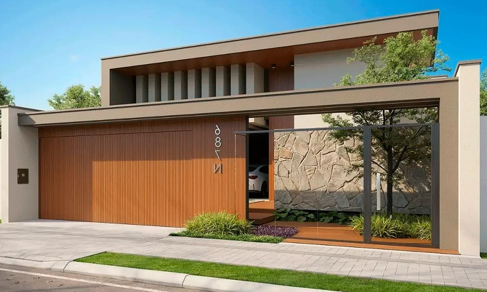 Casa moderna de dois andares com fachada de madeira e pedra, grande entrada de vidro e paisagismo minimalista em frente a um portão de entrada fechado com um elegante porcelanato para garagem.